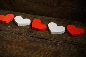 Red and white hearts on old shabby wooden background photo