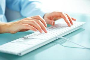 Woman office worker typing on the keyboard photo