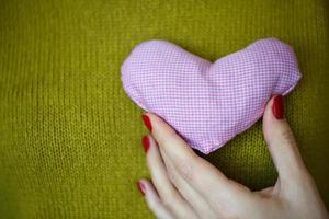 de cerca en rosado corazón en mano de mujer foto