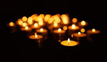 Lit-up candles on black background photo