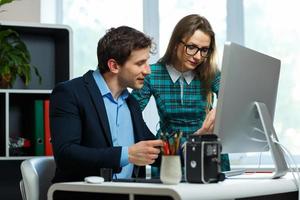 Young colleague - man and woman working from home - modern business concept photo