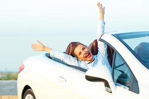 Freedom - happy free woman in cabriolet cheering joyful with arms raised photo