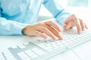 Woman office worker typing on the keyboard photo