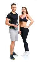 Sport couple - man and woman with dumbbells on the white photo