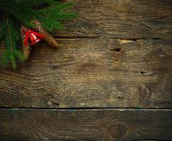 Christmas tree branches with cones and christmas decorations on wooden texture ready for your design photo