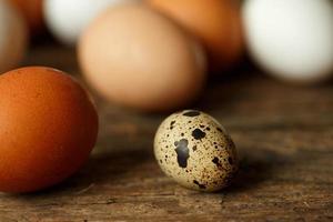Chicken and quail eggs on a wooden rustic background photo