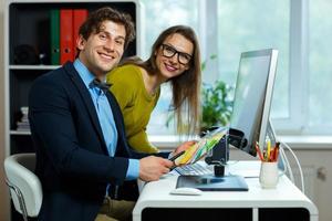 Young colleague looking to a color paint palette at home office photo