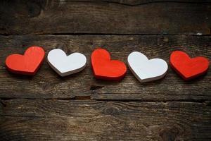 Red and white hearts on old shabby wooden background photo