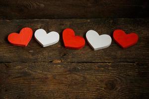 Red and white hearts on old shabby wooden background photo