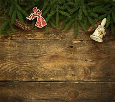 Christmas tree branches with cones and christmas decorations on wooden texture ready for your design photo