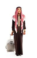 joven sonriente árabe con un maleta aislado en blanco foto