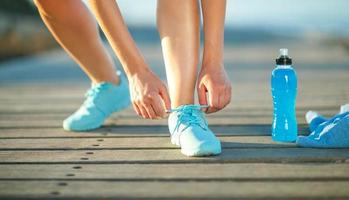Running shoes - woman tying shoe laces photo