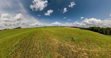 grön liten planet omvandling med krökning av Plats bland fält i solig dag med klar himmel och skön moln video