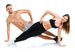 Sport attractive couple - man and woman doing fitness exercises on the white photo