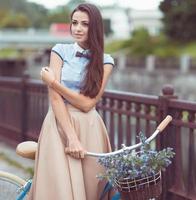 joven mujer hermosa, elegantemente vestida con bicicleta foto