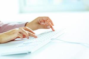 Woman office worker typing on the keyboard photo