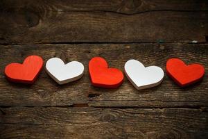 Red and white hearts on old wooden background photo