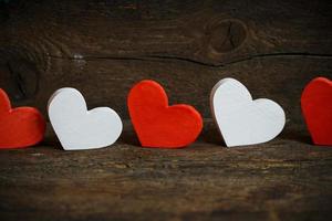 Red and white hearts on old shabby wooden background photo