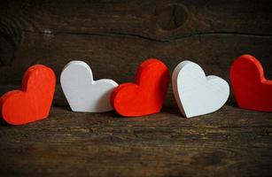 Red and white hearts on old shabby wooden background photo