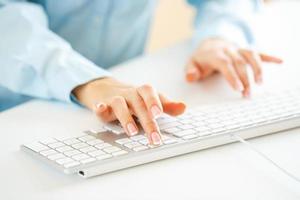 Woman office worker typing on the keyboard photo