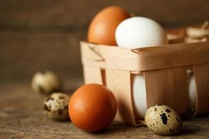 Chicken and quail eggs on a wooden rustic background photo