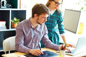 Beautiful young woman and man working from home photo