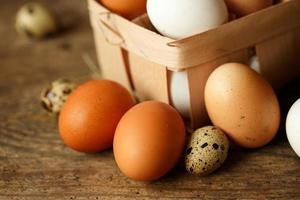 Chicken and quail eggs on a wooden rustic background photo