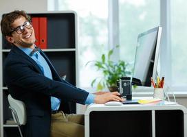 Handsome young man working from home office photo