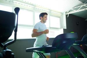 Man doing cardio training program in fitness center photo