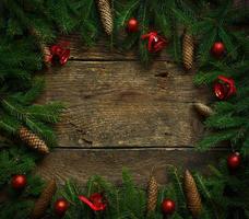 Christmas tree branches with cones and christmas decorations on wooden texture ready for your design photo