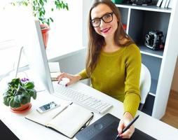 Artist drawing something on graphic tablet at the home office photo