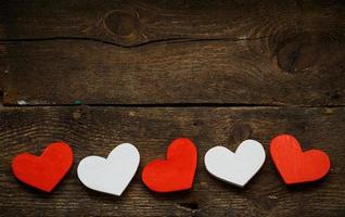 Red and white hearts on old wooden background photo