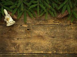 Christmas tree branches with cones and christmas decorations on wooden texture ready for your design photo