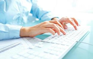 Woman office worker typing on the keyboard photo