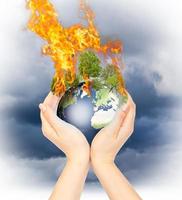 Womanish hands holding burning Earth. photo