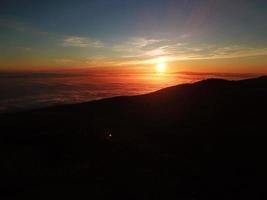 puesta de sol en el teide nacional parque con vista a un mar de nubes debajo tu pies. tenerife, canario islas foto