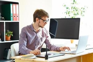 Artist drawing something on graphic tablet at the home office photo