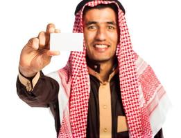 joven sonriente árabe demostración negocio tarjeta en mano aislado en blanco