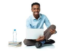 contento africano americano Universidad estudiante con computadora portátil, libros y botella de agua sentado en blanco foto