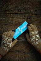 Hands in winter gloves with christmas gift box photo