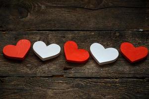 Red and white hearts on old shabby wooden background photo