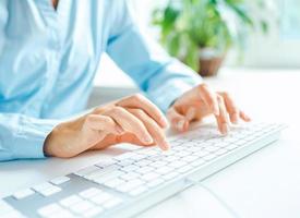 Woman office worker typing on the keyboard photo