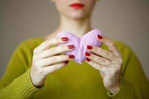 Closeup on pink heart in hand of woman photo