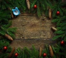Christmas tree branches with cones and christmas decorations on wooden texture ready for your design photo