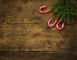 Christmas tree branches with candy canes on wooden texture ready for your design photo