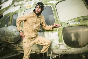 Young pilot posing near the helicopter photo