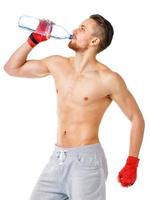 deporte atractivo hombre vistiendo boxeo vendajes y Bebiendo Fresco agua foto
