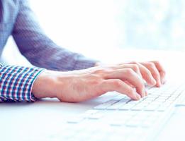 Male hands or men office worker typing on the keyboard photo