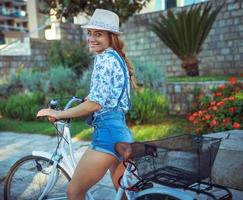 Happy woman riding on bike outdoors photo