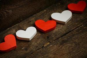 Red and white hearts on old shabby wooden background photo